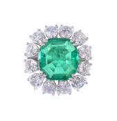 An emerald and diamond cluster ring, the square shaped emerald with canted...  An emerald and
