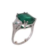 An emerald and diamond ring, the rectangular shaped emerald, stated to weigh 7  An emerald and