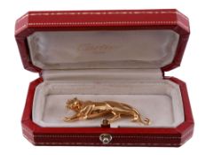 A gold Panthere brooch by Cartier, the polished crouching panther with...  A gold Panthere brooch by