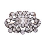 A Victorian diamond brooch, circa 1870, the scrolling panel set with a...  A Victorian diamond