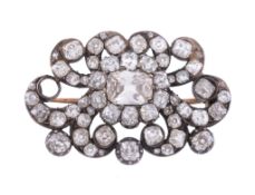 A Victorian diamond brooch, circa 1870, the scrolling panel set with a...  A Victorian diamond