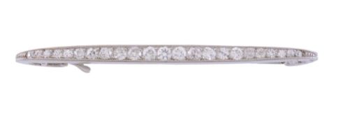 A diamond brooch by Cartier, set along the line with graduated brilliant cut...  A diamond brooch by