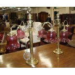 A pair of Victorian brass three branch  candalabra with cranberry shades.   (sold as parts)