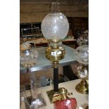 A brass and clear glass oil lamp  , another, a silver coloured metal and clear glass oil lamp, and