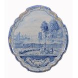 A Dutch Delft blue and white shaped oval plaque,   19th century, decorated with a fishing scene,