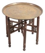A brass topped folding occasional table,   with pierced stand and two Islamic brass trays of