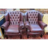 A pair of Georgian style leather wing armchairs.