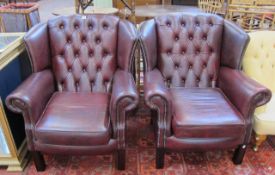 A pair of Georgian style leather wing armchairs.