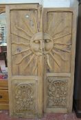 A pair of early 20th century pine doors with sunburst panels over floral panels below.Each door is