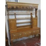 A pine dresser   with open plate rack on a base raised on cabriole legs. 213cm x 166cm