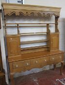 A pine dresser   with open plate rack on a base raised on cabriole legs. 213cm x 166cm
