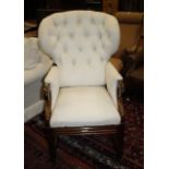 A reclining armchair   covered in calico button back upholstery, with scrolled arms on square