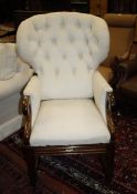A reclining armchair   covered in calico button back upholstery, with scrolled arms on square