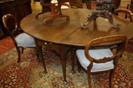 A George II style oak drop leaf dining table   with an oval top on turned legs and pad feet 77cm