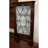 An oak standing corner cupboard  , with fluted canted corners flanking an astragal glazed door, on