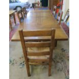 A large plank top refectory dining table   with two draw leaf extensions and six ladder back