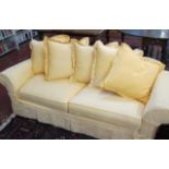 A modern three seater sofa   with loose yellow covers. 230cm wide.