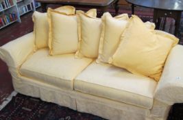A modern three seater sofa   with loose yellow covers. 230cm wide.