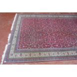 A Middle Eastern carpet   with a field of flowers on a red ground.300cm x 200cm.