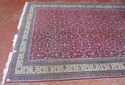A Middle Eastern carpet   with a field of flowers on a red ground.300cm x 200cm.