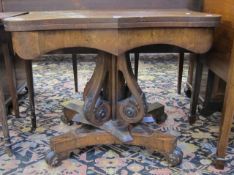 A Regency rosewood serpentine card table  , on a scrolled turned pedestal and quadraform base.