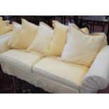 A modern three seater sofa   with loose yellow covers.230cm wide.