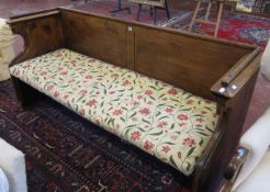 A 19th century pitch pine church pew   with raised back and sides with full length pad cushion.