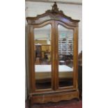 A 19th Century French Armoire  , walnut with a Rococo scrolled cornice,over two mirrored doors and