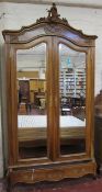 A 19th Century French Armoire  , walnut with a Rococo scrolled cornice,over two mirrored doors and