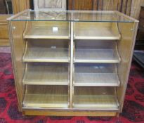 A Draper's cabinet   with a full length glazed front with two rows of four graduated drawers