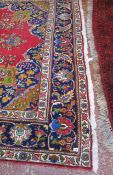 A Persian style carpet   with a central medallion and floral motif on a red ground.340cm x 245cm
