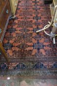 An Afghan carpet   with an all over geometric pattern on a  rusty coloured ground.350cm x 260cm