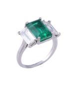 An emerald and diamond ring, the rectangular shaped emerald  An emerald and diamond ring,   the