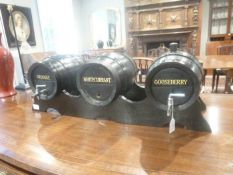 A rack of three wine barrels, second half 19th century and later, black painted throughout, titled
