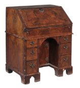 A George II walnut bureau  , circa 1735, the fall opening to leather inset writing surface, an