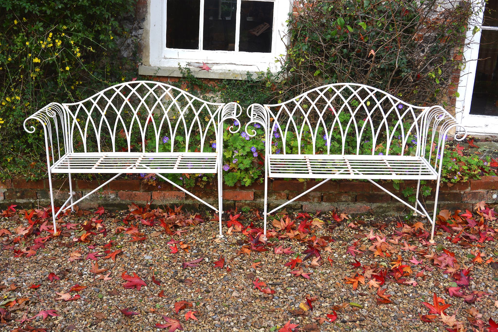 A pair of white painted metal garden seats,   loosely in the George III style, late 20th century,