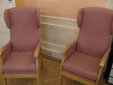 Two pink upholstered wingback arm chairs
