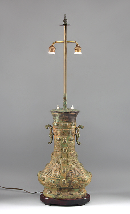 Tischlampe China. Vasenförmiger Relieffuß aus grün patinierter Bronze, ovaler Holzstand. H mit