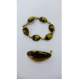 A 9ct gold and tiger's eye cabouchon bracelet together with a tiger's eye brooch set in a 9ct gold