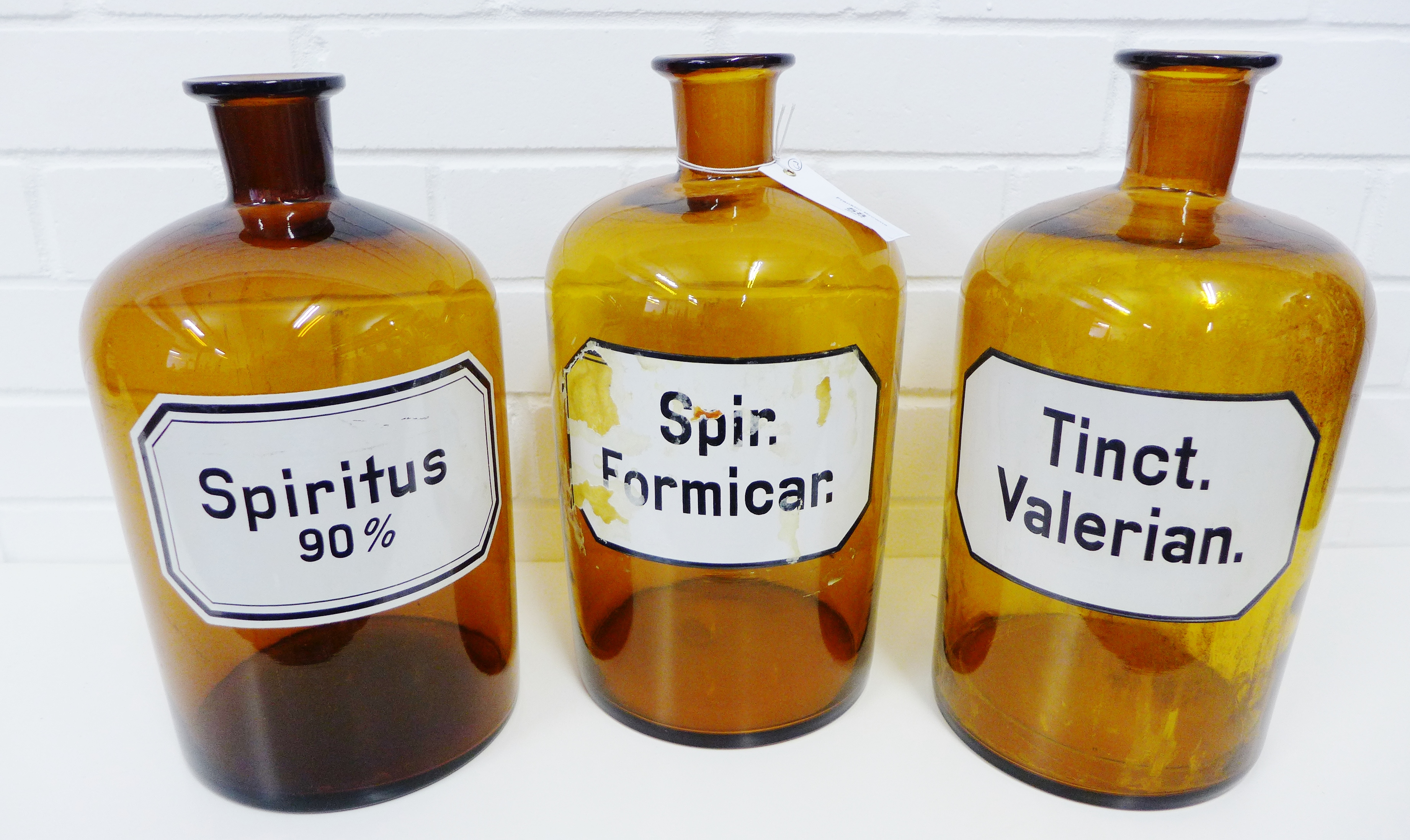 A set of three amber glass chemist bottles/jars, labelled for Tinct Valerian, Spir Formicar, and