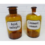 Two amber glass chemist bottles/jars labelled for Liniment ammon and Acid salicylic, with flat top