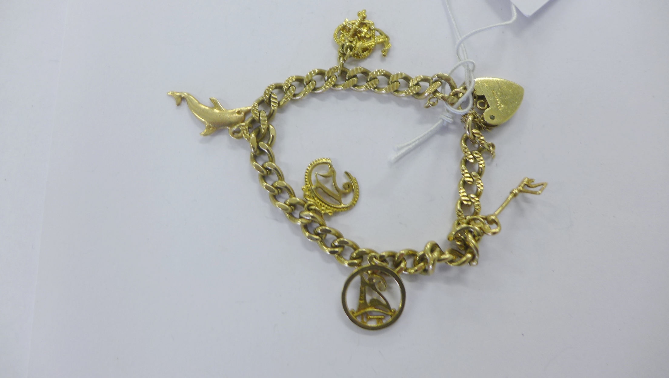 9ct gold bracelet hung with an assortment of 9ct gold charms (21 grams approx)