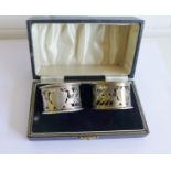 A pair of Chester silver pierced napkin rings, with thistle pattern and vacant shield cartouche,