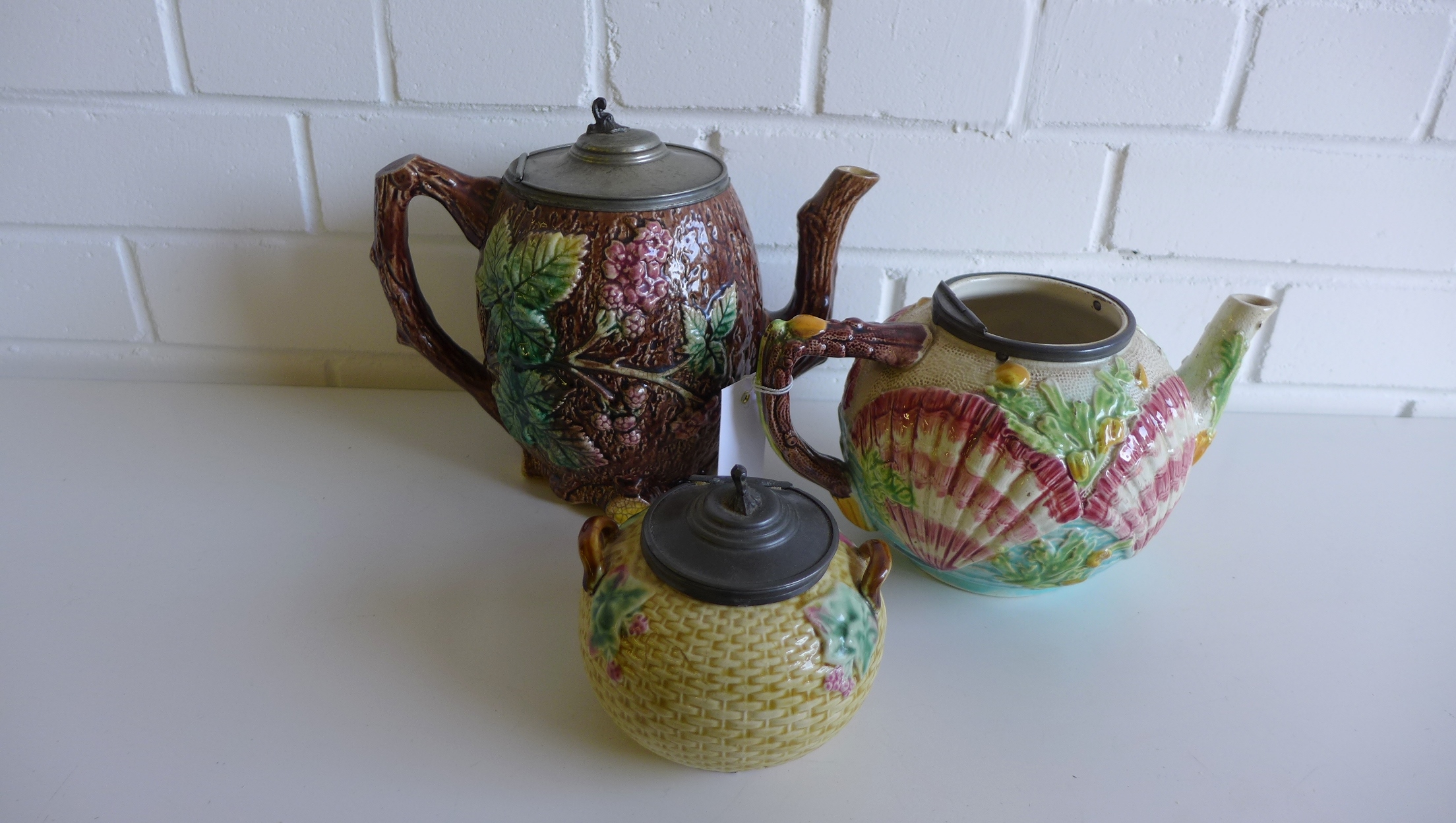 19th century majolica teapot, the body relief decorated with shells together with a fruit and vine