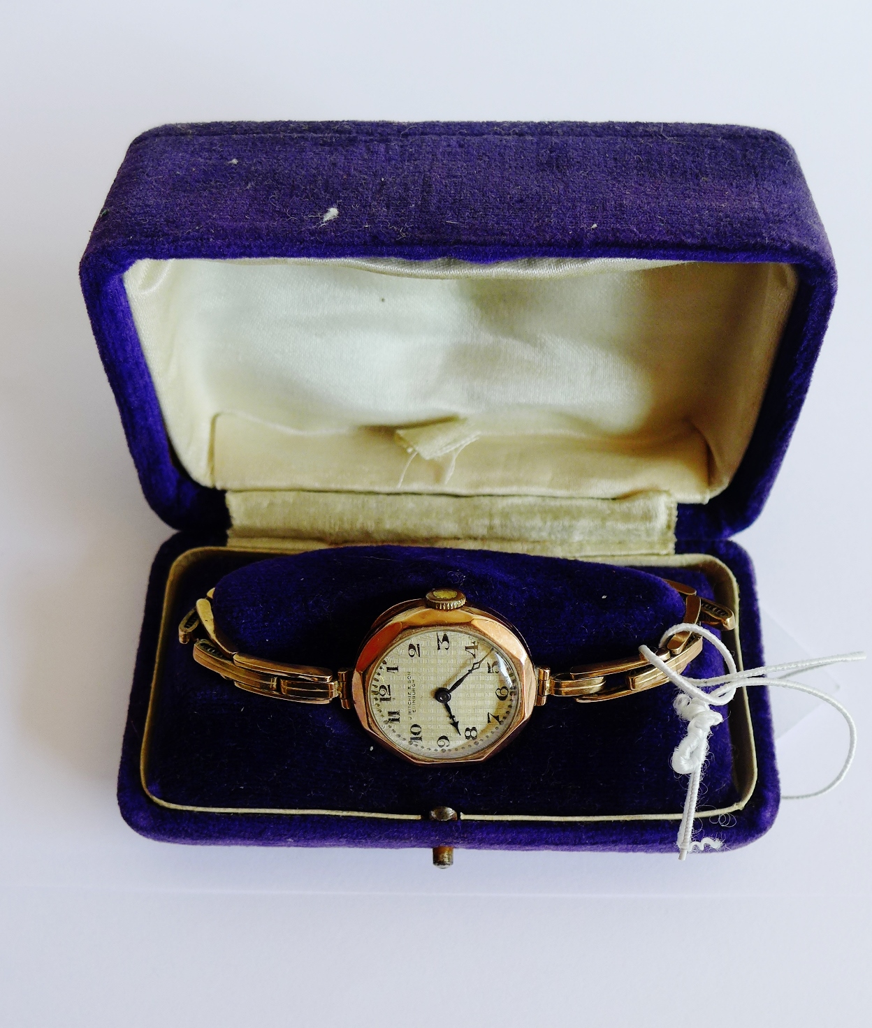 Lady's 9 carat gold cased wristwatch, the octagonal enamel dial with Arabic numerals and retailer'