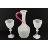 An opaline glass water set, comprising two goblets and a jug, the stems, neck and handle detailed in