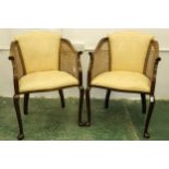 A pair of mahogany bergere style armchairs upholstered in cream with caned arms, c1850 (2)