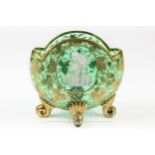 A Moser green glass vase, of shell form on four scroll feet, enamelled in white with a bust of a