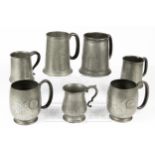 Seven pewter mugs, some examples with golfing theme including a 'Tudric' mug in the form of a golf