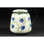 A Moorcroft MacIntyre Florian ware jug, the cream ground tubelined with blue anemones and forget-